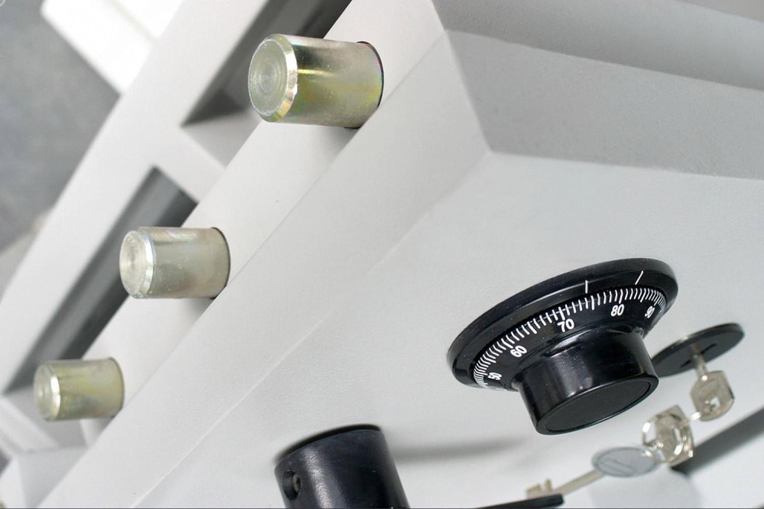 Close-up of a home safe's steel locking bolts and combination dial